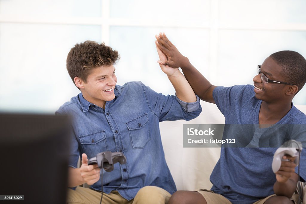 Multi-ethnische teen Jungen spielen Videospiele.  High-five. - Lizenzfrei Afrikanischer Abstammung Stock-Foto