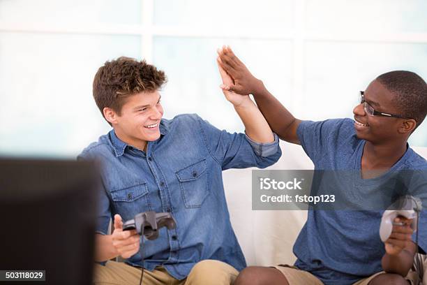Multiethnic Teen Boys Play Video Games Highfive Stock Photo - Download Image Now