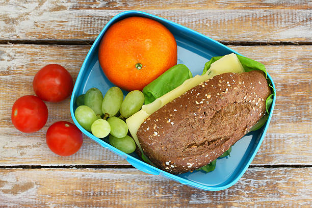 istock Healthy school lunch box containing brown cheese roll, mandarine, grapes 503118366