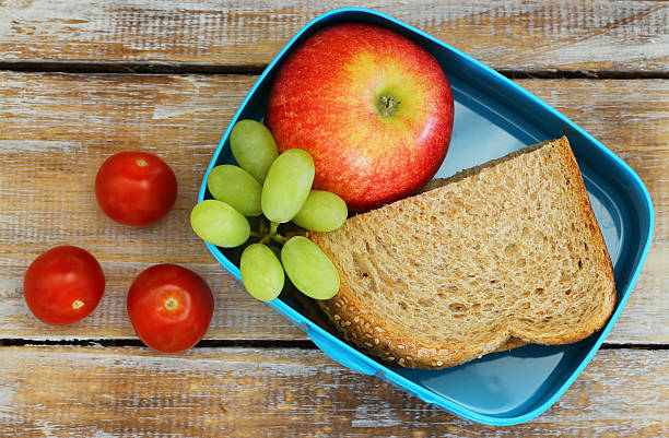 istock Lunch box containing brown bread sandwich, red apple, grapes, tomatoes 503118504