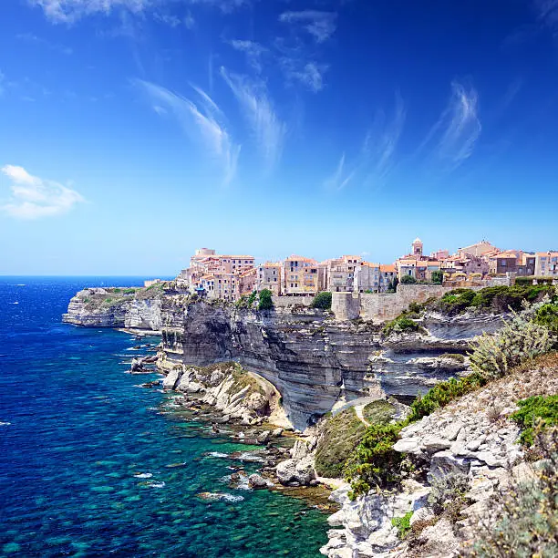 Houses of Bonifacio atop steep cliffs above the Mediterranean sea, Corsica, France. Composite photo