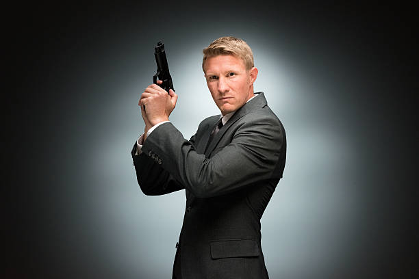 istock Spy holding handgun and looking at camera 503129308