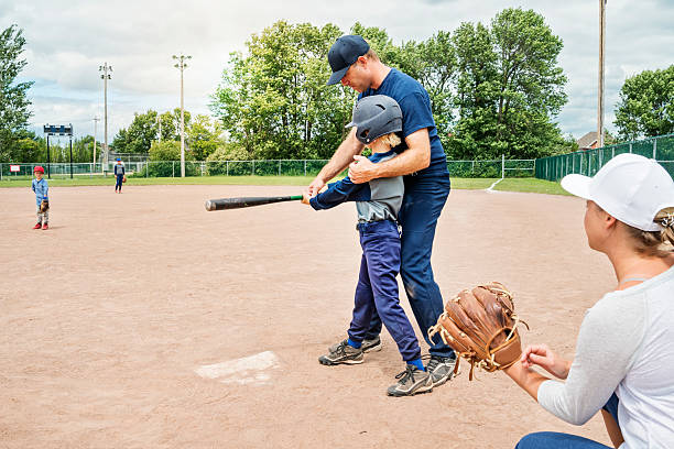 istock Mom, dad and their three boys playing baseball in summer. 503131505