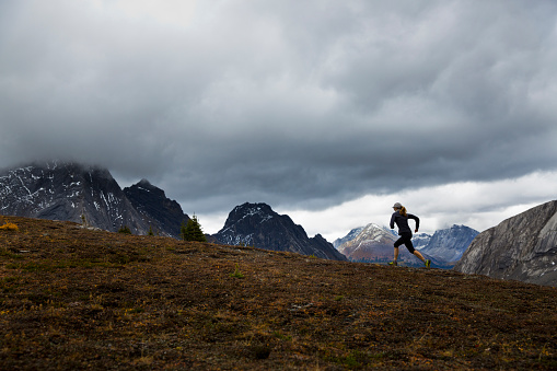 A woman enjoys a rainy day run in the Rocky Mountains of Alberta, Canada.