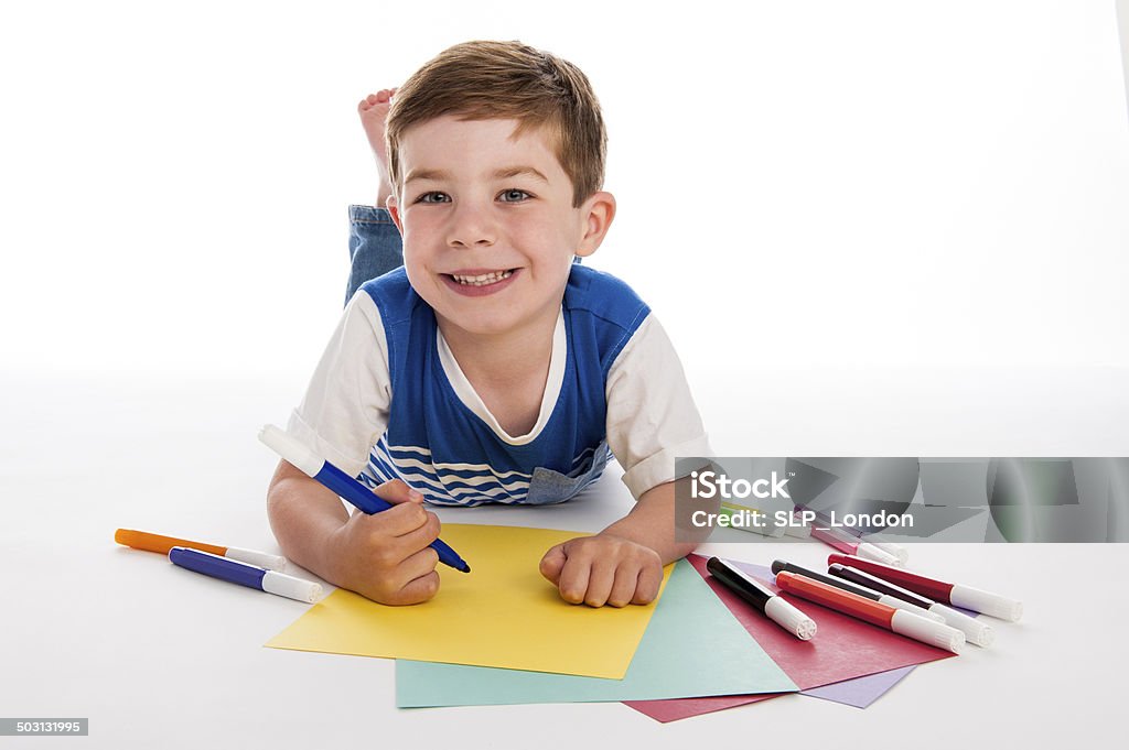 Giovane ragazzo disegno su carta colorata. - Foto stock royalty-free di Bambino