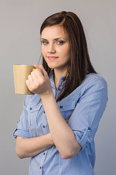 istock Smiling pretty brunette holding cup of coffee 503133003