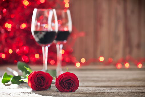 Valentine's day wine, red roses on old wood rustic background