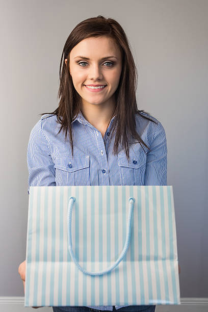 istock Cheerful pretty brunette offering a present 503133661