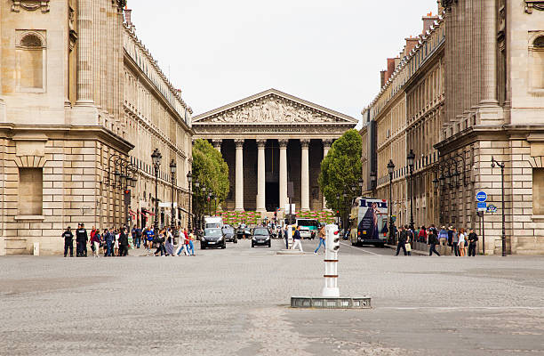 Paris, France - September 8, 2013: Tourists and locals cross the Royale street under the watchful eyes of the gendarmes. View from La Place de la Concorde, looking down Rue Royale towards the church of La Madeleine.