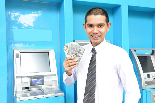 asian empresário segurando o dinheiro-dólares americanos (usd) - bank teller bank check asian ethnicity - fotografias e filmes do acervo