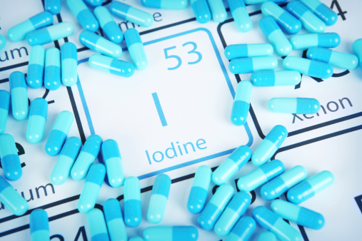 Iodine with capsules or pills on the periodic table (Periodic table made by me)  Stock image representing mineral supplementation.