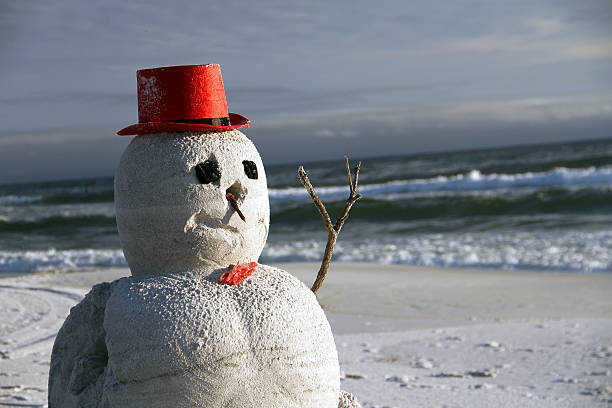 istock Snow Christmas snowman in santa hat at sandy beach 503139216