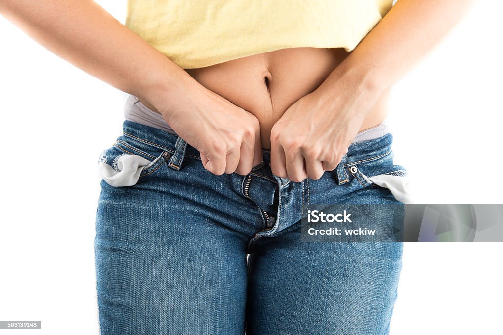 Woman trying to close jeans button with difficult from fat Too Small Stock Photo