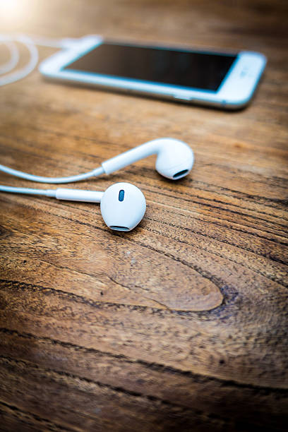 istock mobile phone and headphones lay on wooden table 503141492