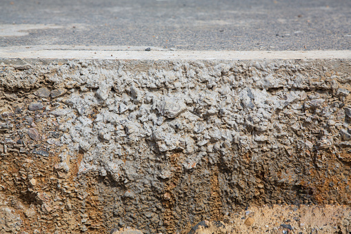 A cross section through a tarmac road surface, showing levels of rock and earth below