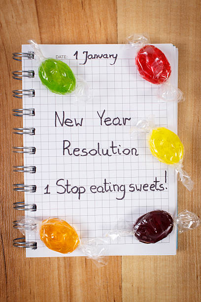 新しい年の解決の文書のノートパソコンやカラフルなキャンディ - dieting planning calendar event ストックフォトと画像