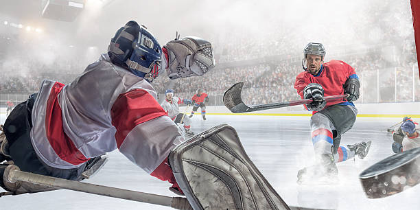 jugador de hockey sobre hielo de puntuación - ice hockey hockey puck playing shooting at goal fotografías e imágenes de stock