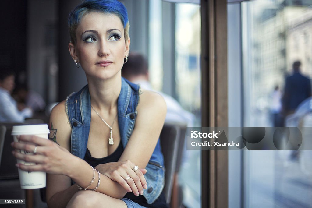 Trendy girl in a cafe Beautiful girl drinking coffee in a cafe Blue Hair Stock Photo