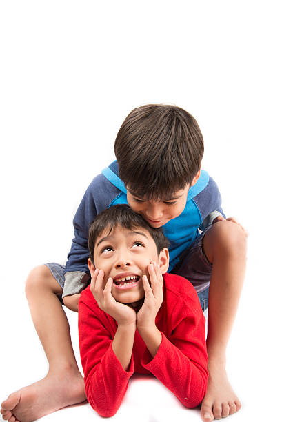 istock Little sibling boys sit together on white background 503155108