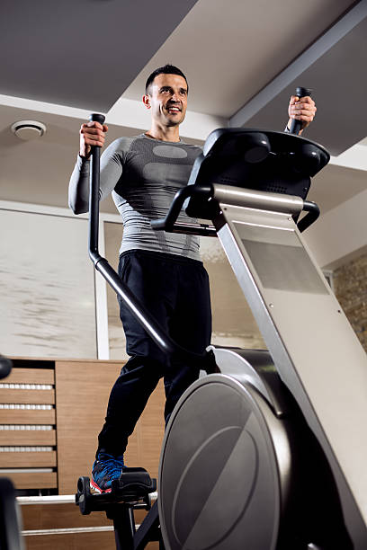 uśmiech sexy mięśni mężczyzna robi cardio szkolenia - running jogging treadmill weight training zdjęcia i obrazy z banku zdjęć