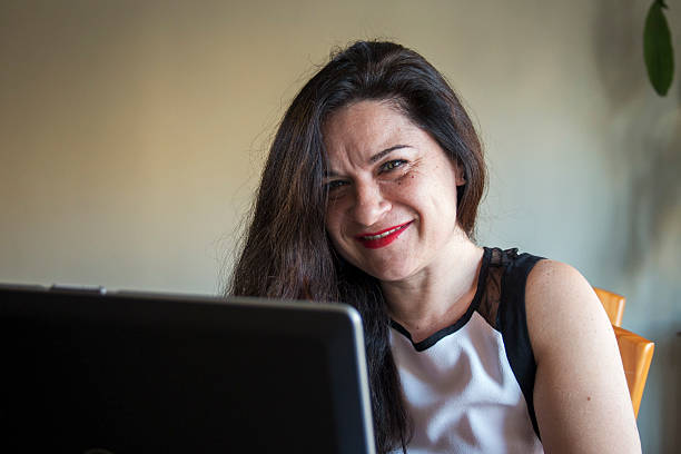 mulher sorridente, trabalhando em seu laptop em casa, escritório de trabalho - efficency - fotografias e filmes do acervo