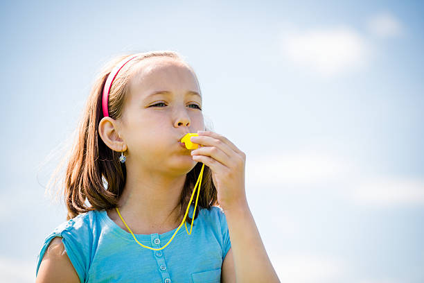 niño soplando whistle - silbar fotografías e imágenes de stock