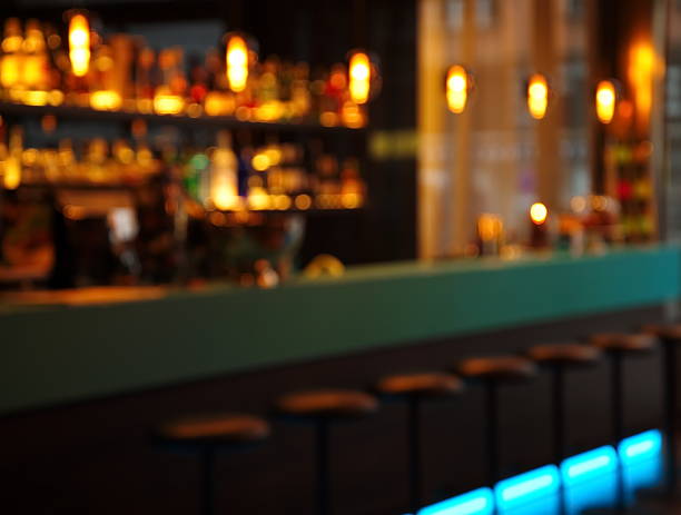 istock blur alcohol drink bottle and stool in pub iat night 503163998
