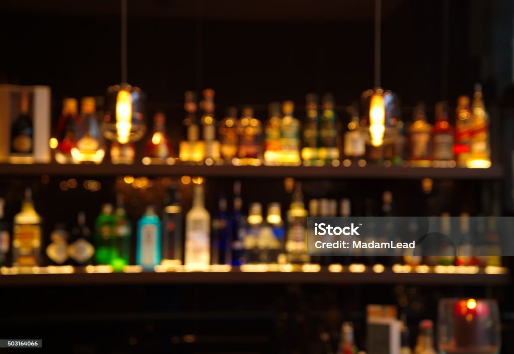 blur alcohol drink bottle at pub in dark night blur alcohol drink bottle at pub in dark night background Bar Counter Stock Photo
