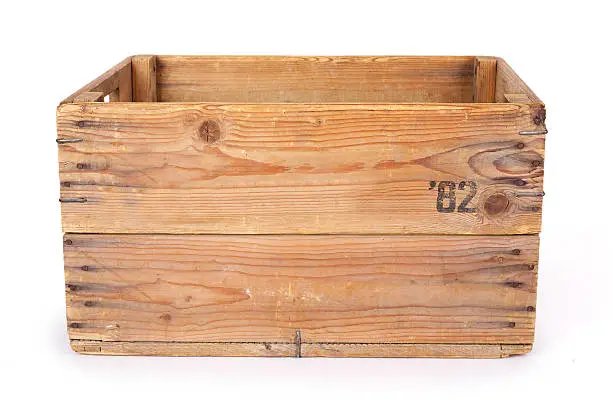 Old wooden box isolated on white background showing signs of extensive use like stains and scratches. These crate's where used for potato storage. 