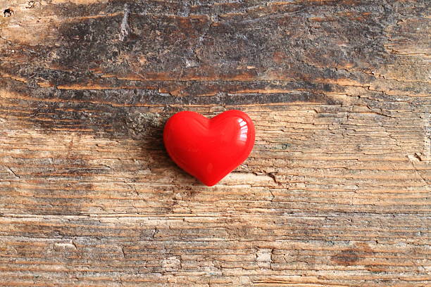 Small red heart on wooden table