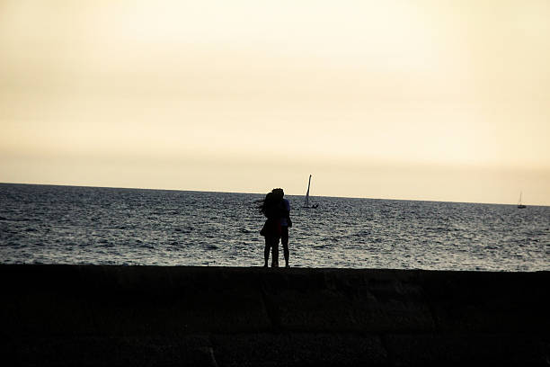 シルエットを包みながら、お探しのカップルには、海の眺め - sailboat sunset tel aviv sea ストックフォトと画像