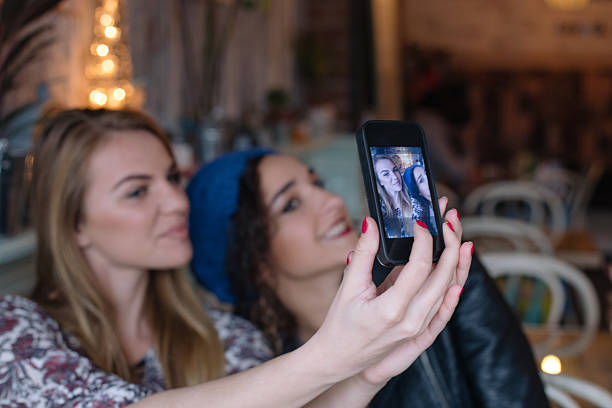 istock Two cheerful friends taking selfie in cafe 503169876