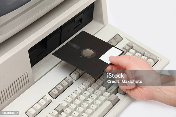 Hand Inserting Old Floppy Disk Drive Into Vintage Eigthies Computer Stock Photo - Download Image Now