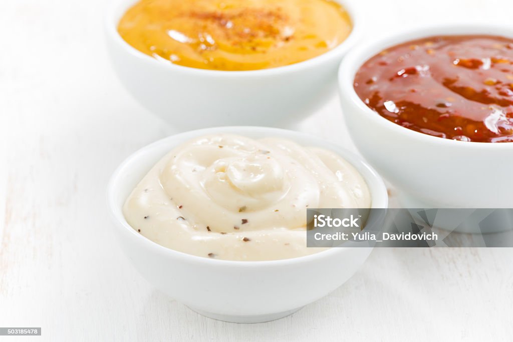 assortment various sauces in bowls on white table assortment various sauces in bowls on white table, closeup Savory Sauce Stock Photo