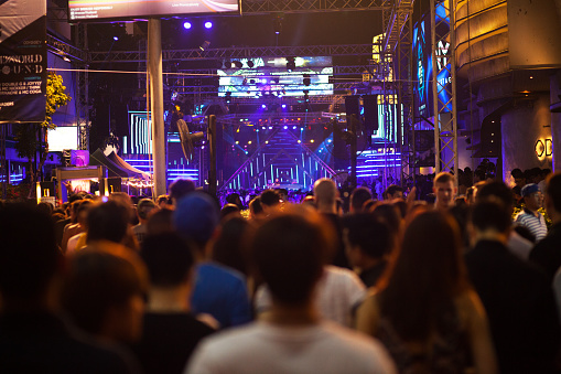 Bangkok, Thailand - December 31, 2015: Capture of crowd at new year party in street RCA. People in foreground are standing in queue for enter party. In background is stage outside of Route 66 bar. Public shot.