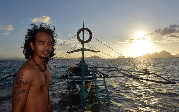 philippino con su tradicional de banca remar embarcaciones en filipinas - outrigger philippines mindanao palawan fotografías e imágenes de stock