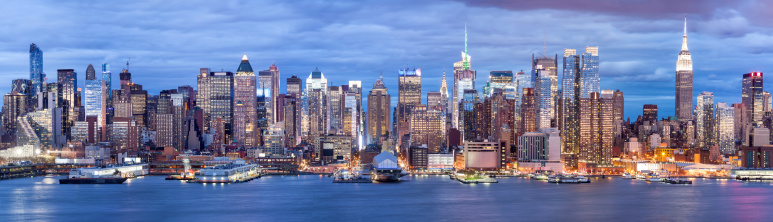panoramic view of Midtown Manhattan at dusk, office buildings in financial district, Hudson river, New York City, horizontally stitched composition, America, USA.