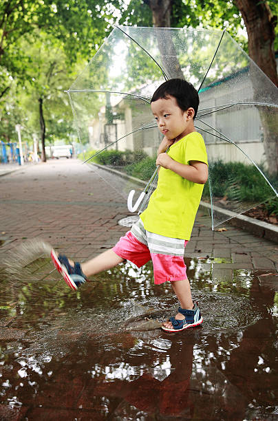 かわいい公園で遊ぶお子様 - rain drenched one person standing ストックフォトと画像