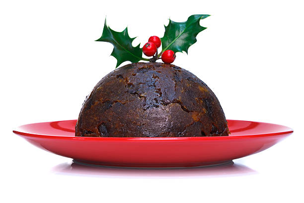 Christmas pudding isolated Photo of a steamed Christmas pudding with holly on top isolated on a white background. christmas pudding stock pictures, royalty-free photos & images