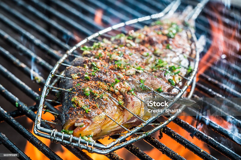 Baked fish on the grill with fire Baked Stock Photo