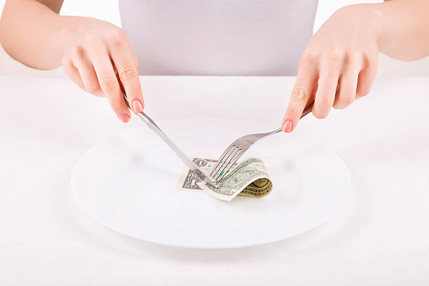 istock Woman with dinnerware and one dollar 503191556