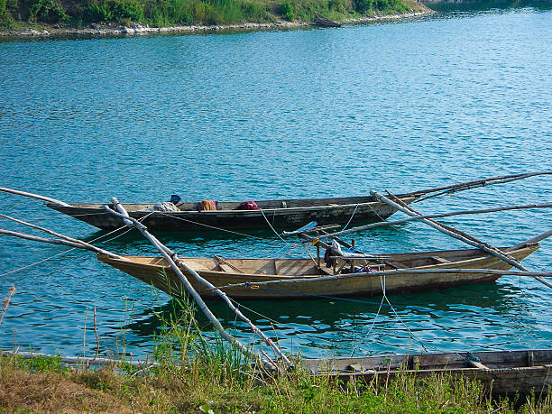 kanu z pływakiem łodzi rybackich wzdłuż brzegu jezioro kiwu rwanda - rowboat fishing africa fishing industry zdjęcia i obrazy z banku zdjęć