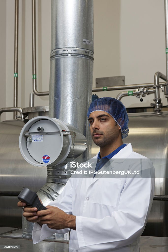 Bottling plant and machinery Worker holding an equipment standing next to pipe 30-34 Years Stock Photo