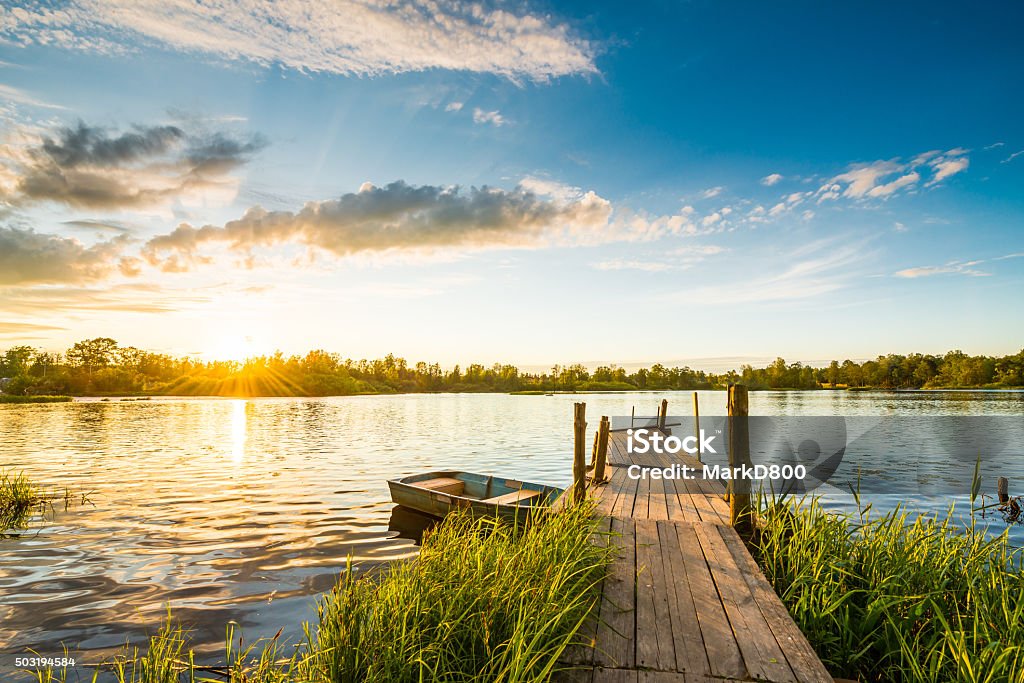 Sunset over the lake in the village Sunset over the lake in the village. View from a wooden bridge Lake Stock Photo