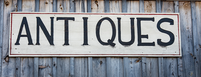 Wooden antiques sign on a wood background in New England