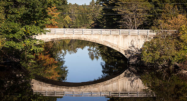 istock reflection of a stone bridge maine 503197610