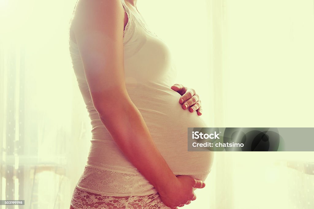 Image of pregnant woman touching her belly with hands Adult Stock Photo