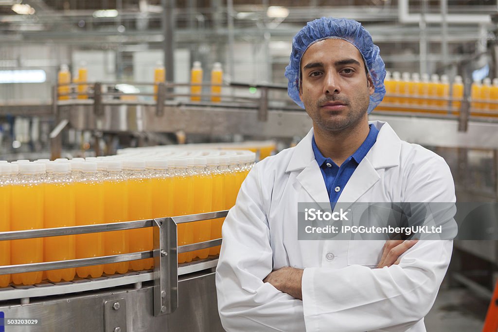 Bottling plant and machinery Portrait of confident factory worker standing with arms crossed Bottling Plant Stock Photo