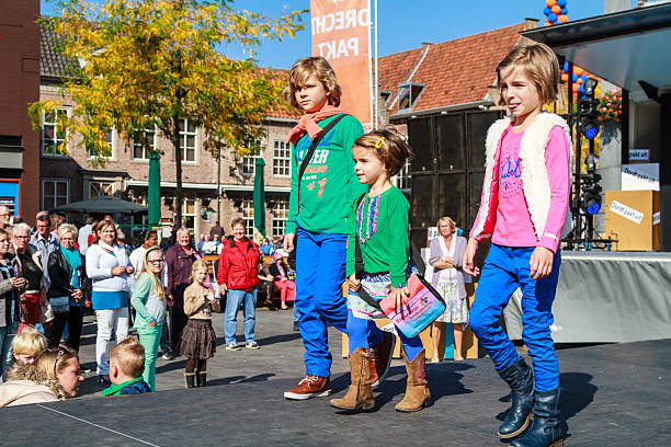 Kids on catwalk Dordrecht, Netherlands – September 29 2013: Free entertainment and fashion show in the main square organized by the municipality. Child models walk on the catwalk showcasing the new autumn collection. dordrecht photos stock pictures, royalty-free photos & images