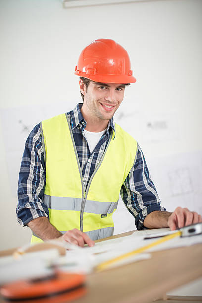 istock foreman in his office reviewing building plans 503206299
